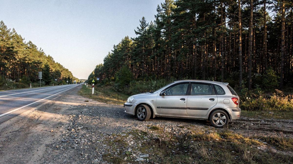 Car parked at a roadside stop on a forest highway outside Kyiv